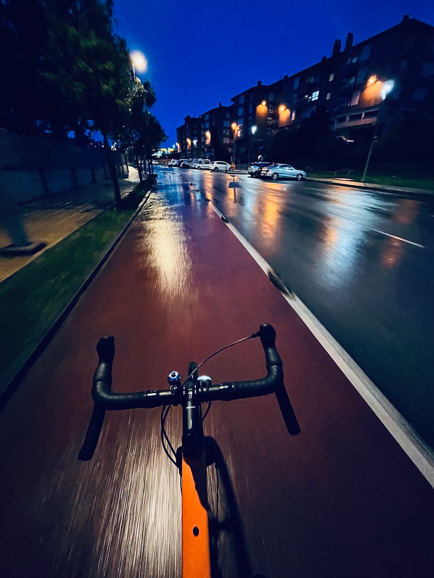 Un carril bici que discurre por la ciudad. Es de noche y llueve ligeramente. Un carril bici que discurre por la ciudad. Es de noche y llueve ligeramente.
