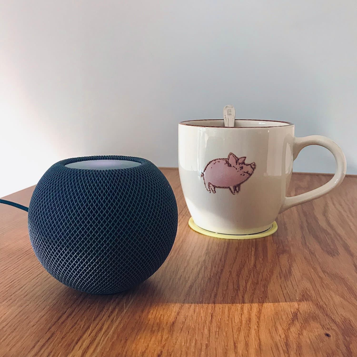 Un Homepod mini y una taza de tachocao con el motivo de un chon Un Homepod mini y una taza de tachocao con el motivo de un chon